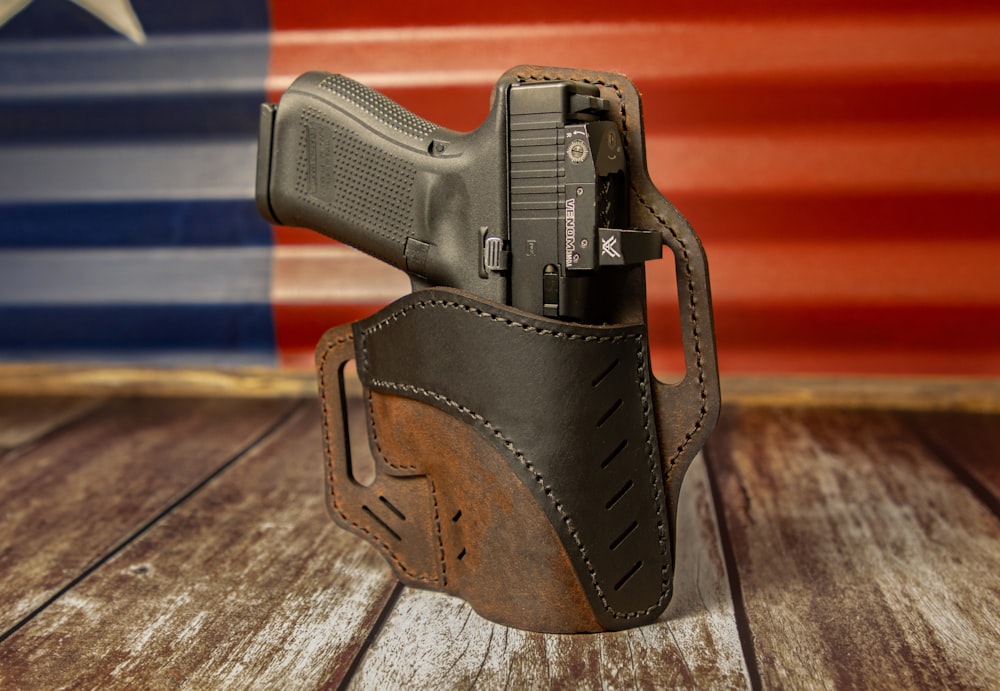 a leather holster with a gun in front of an american flag