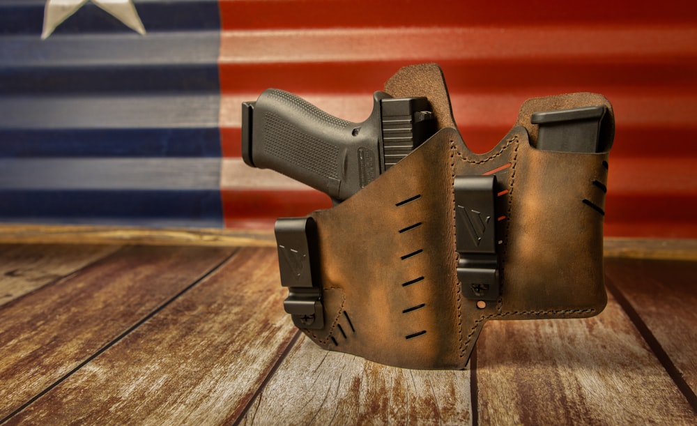 a leather holster with a gun in front of an american flag