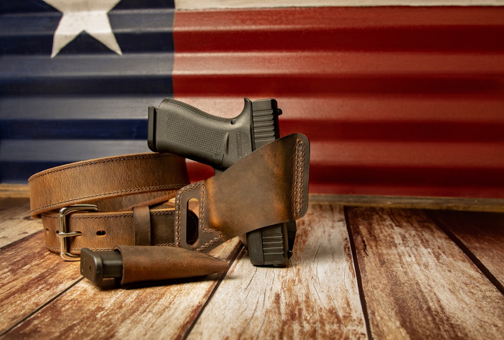 a gun and a holster on a wooden table