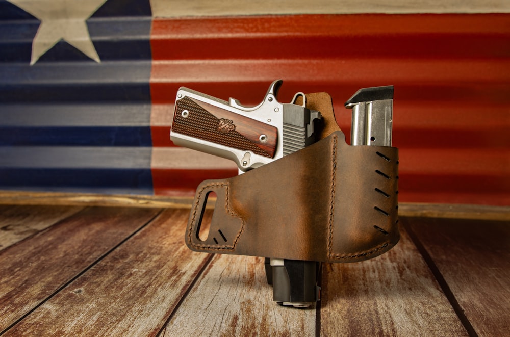 a leather holster with a gun in front of an american flag