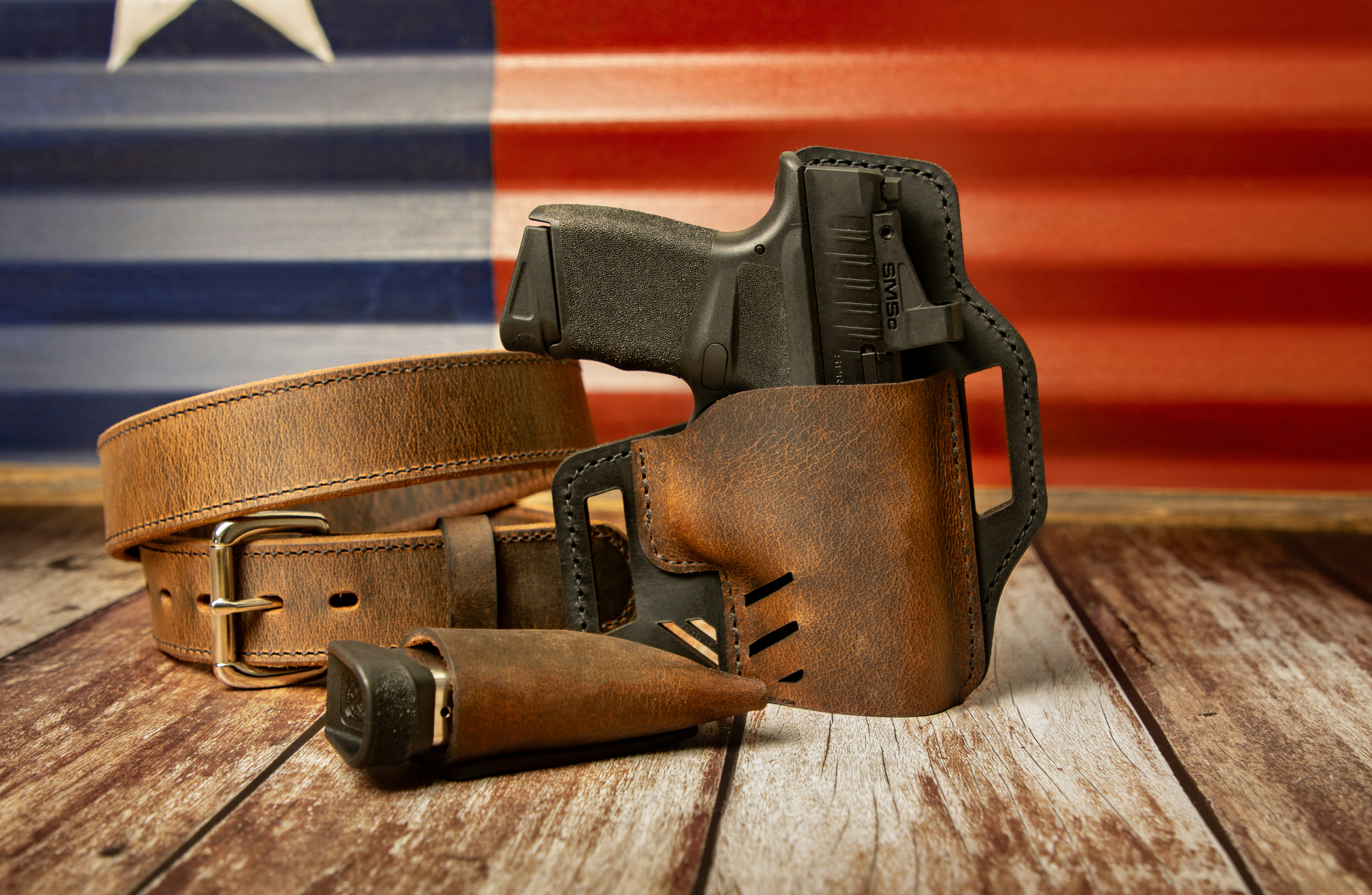 a leather belt with a gun and a holster on a wooden table