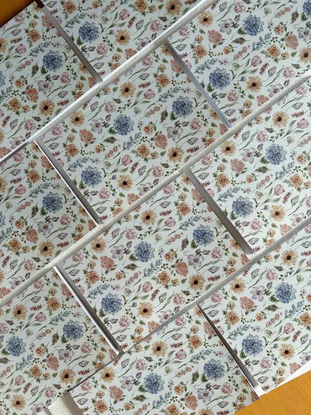 a close up of a tiled wall with flowers on it