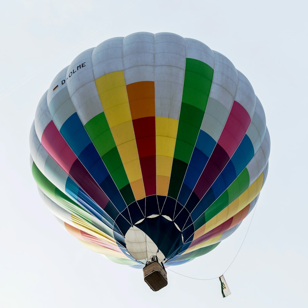 a multicolored hot air balloon flying in the sky