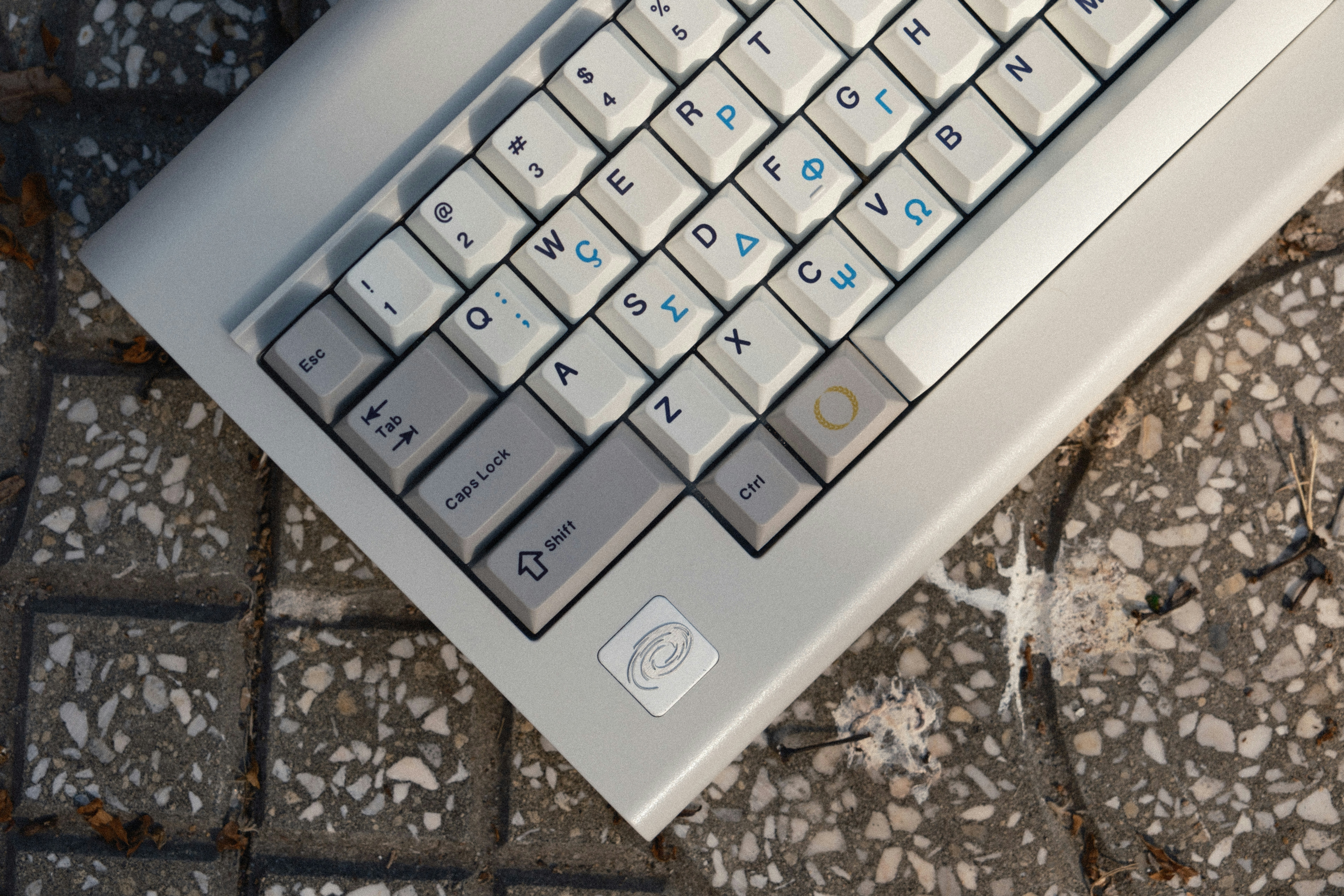 a white laptop computer sitting on top of a stone floor