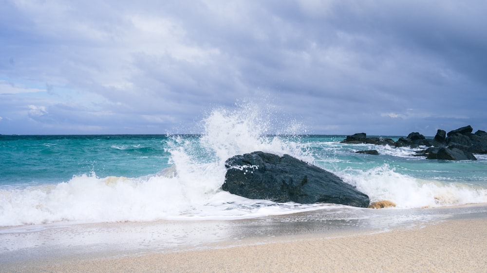 a large rock sitting on top of a sandy beach