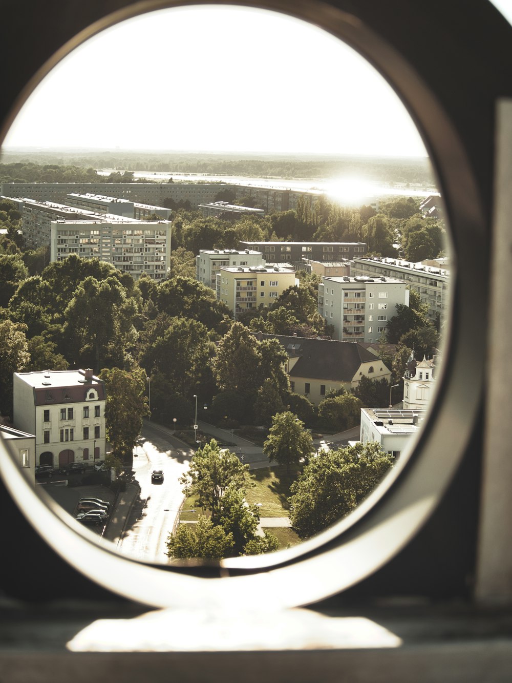 Blick auf eine Stadt durch ein rundes Fenster