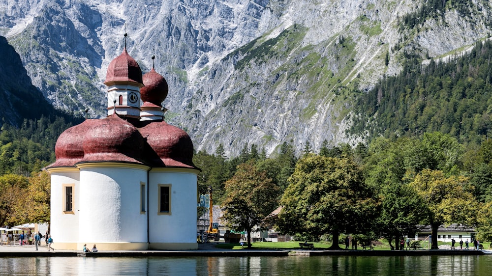 a white and red church sitting in the middle of a lake