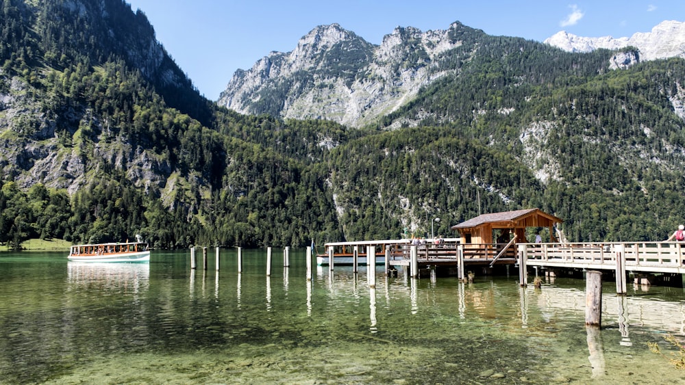 a boat is docked at a pier in a mountain lake