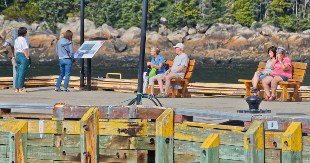 a group of people sitting on top of wooden benches