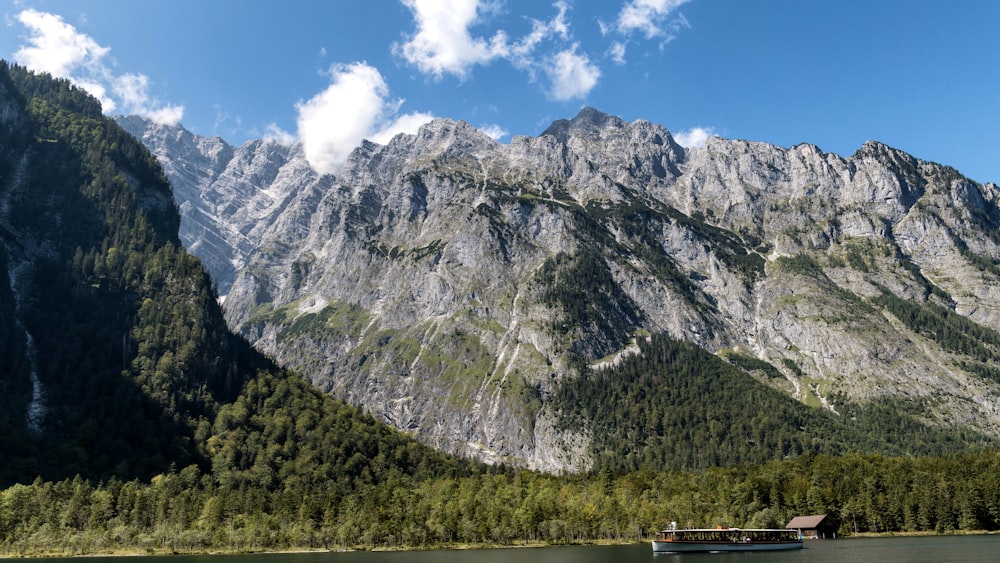 a boat floating on top of a lake surrounded by mountains