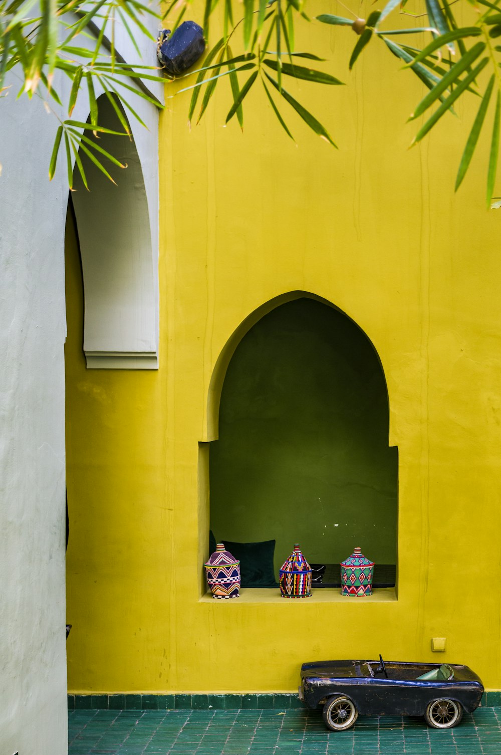 a toy car sitting in front of a yellow wall