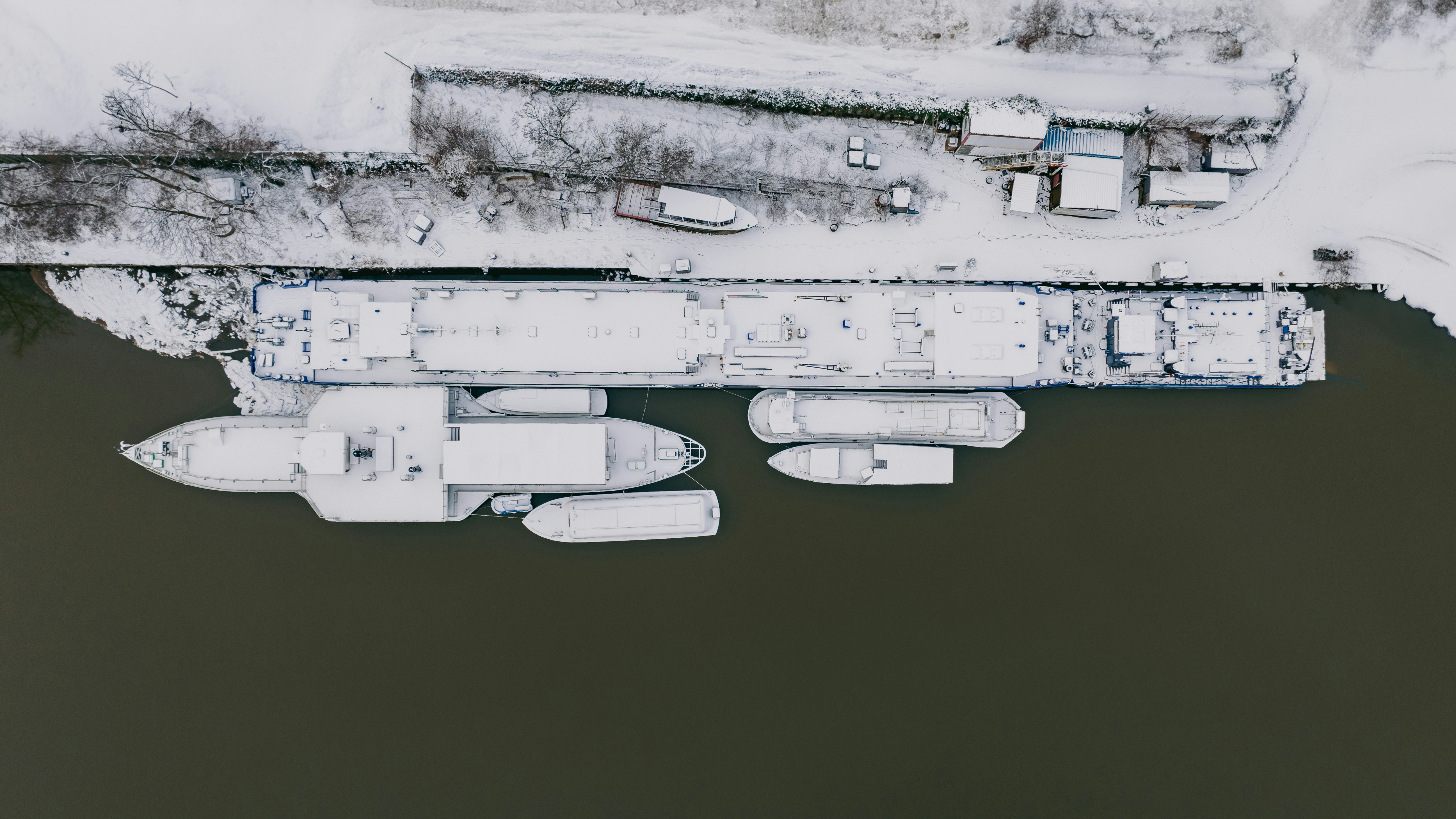 an aerial view of a boat dock in the snow