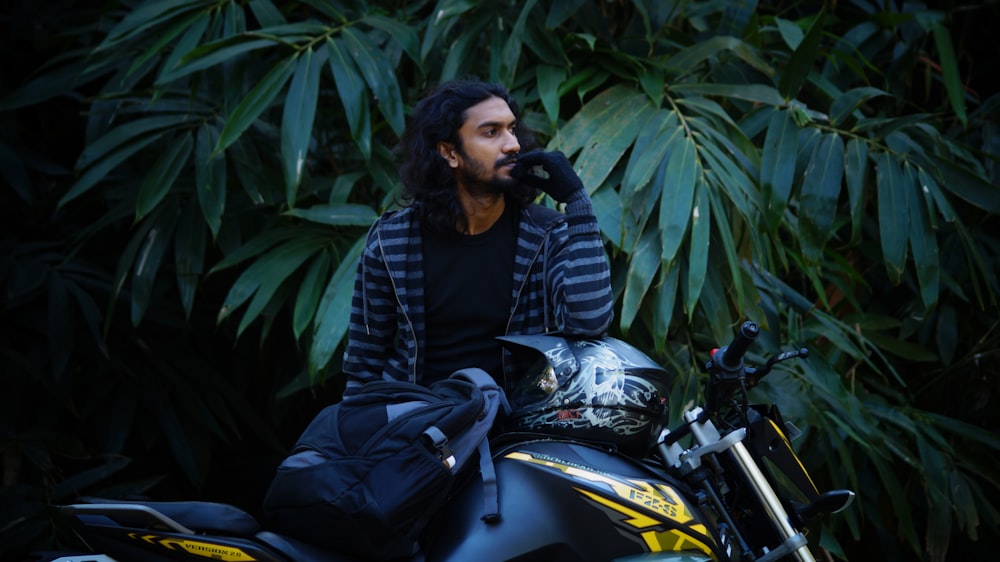 a man with long hair sitting on a motorcycle