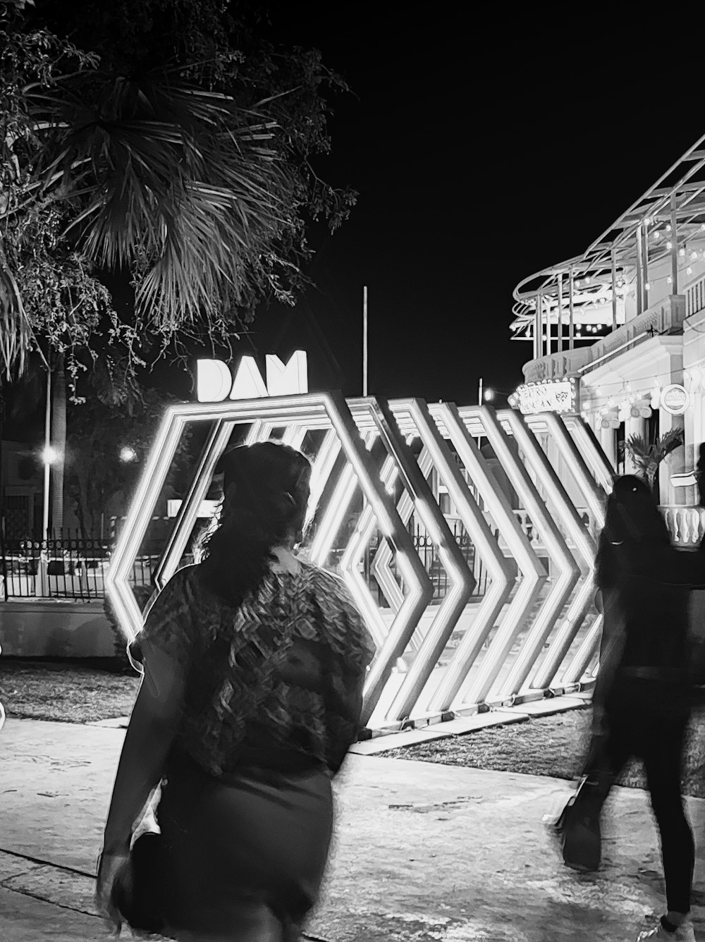 a black and white photo of people walking in front of a building