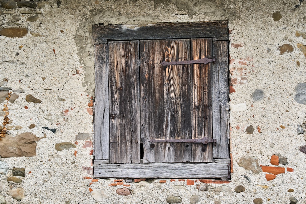 an old wooden window on a stone wall