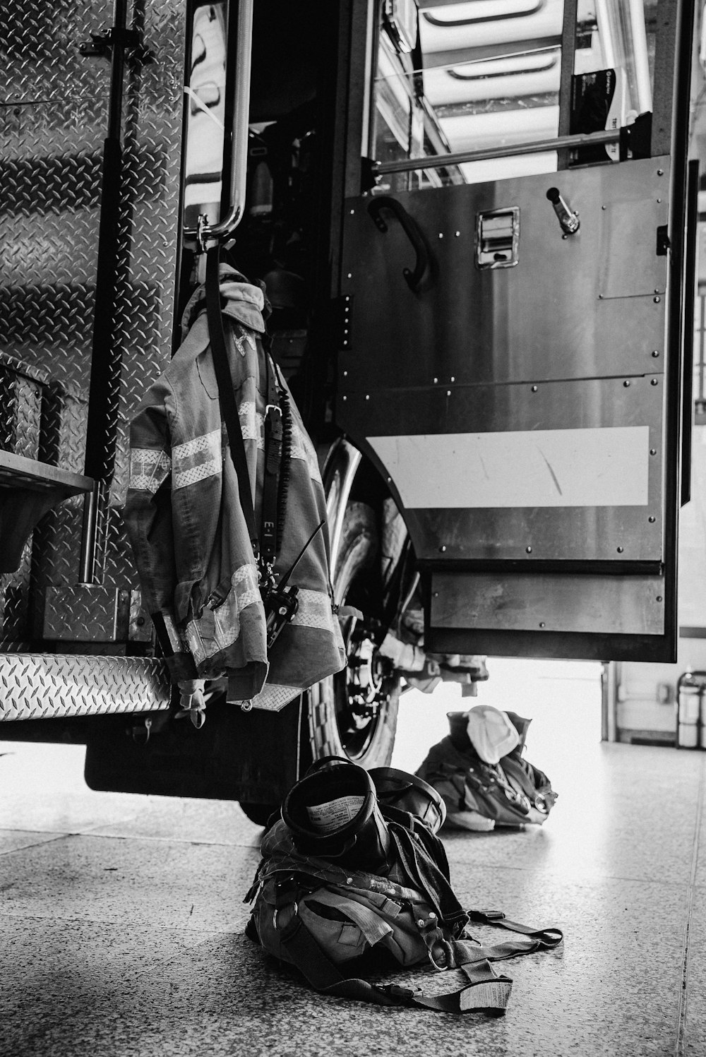 a black and white photo of a fire truck with a fireman's gear