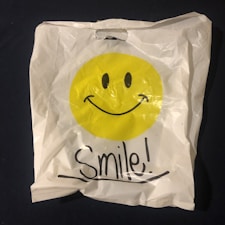 a white bag with a smiley face drawn on it cadeaux insolites pas chers