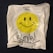 a white bag with a smiley face drawn on it