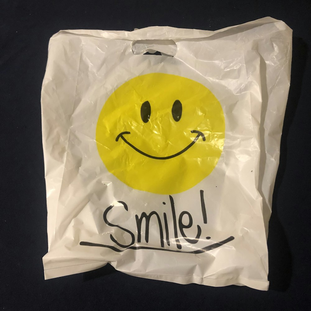 a white bag with a smiley face drawn on it