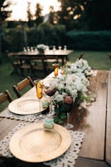 a wooden table topped with plates and flowers