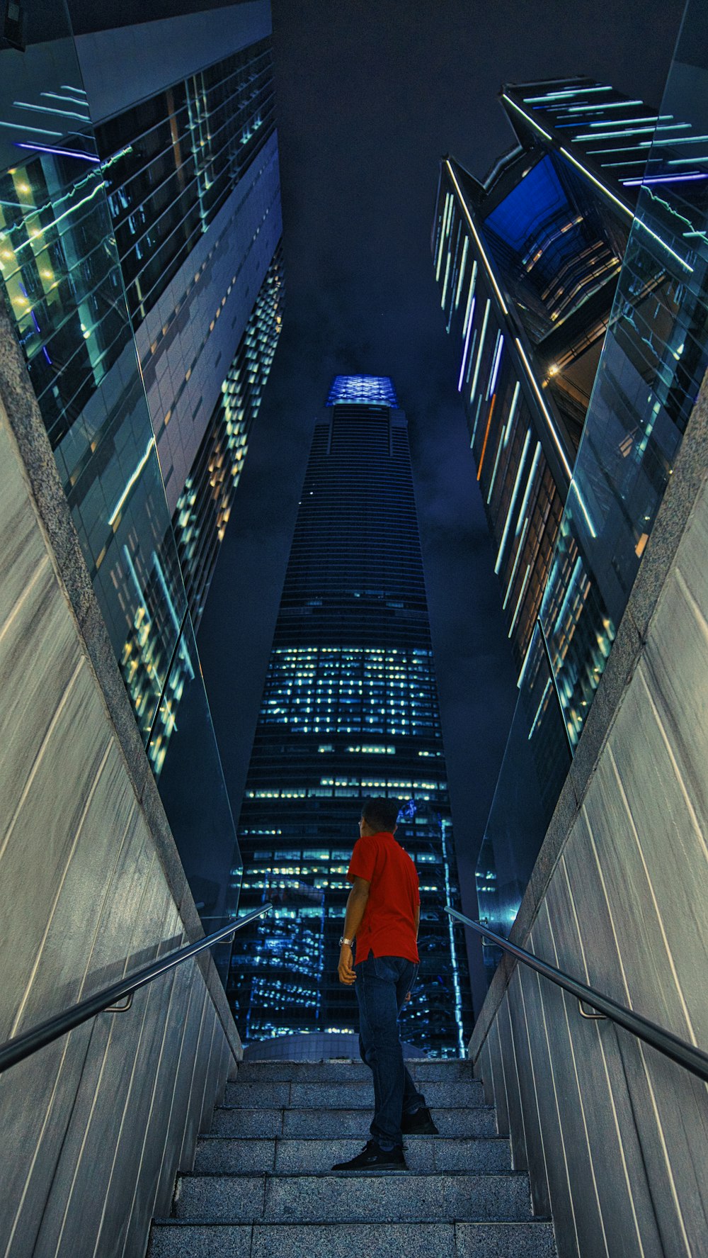 a man walking up a flight of stairs in a city at night