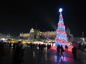 a large christmas tree is lit up in front of a building