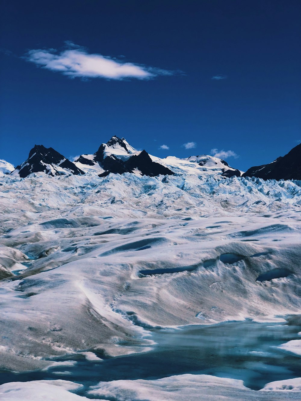 a view of a glacier with mountains in the background
