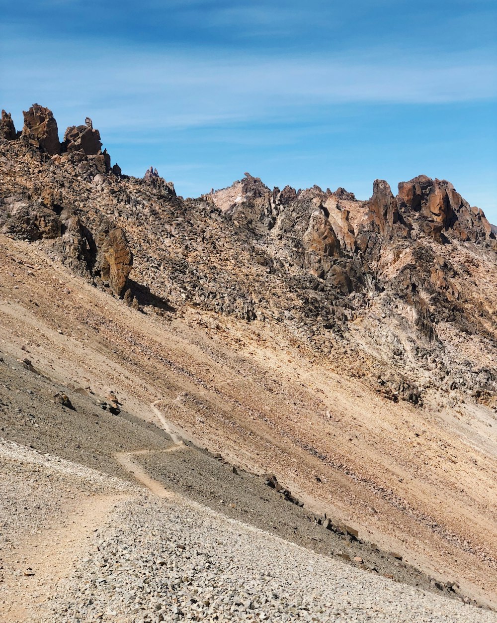 a rocky mountain with a trail going through it