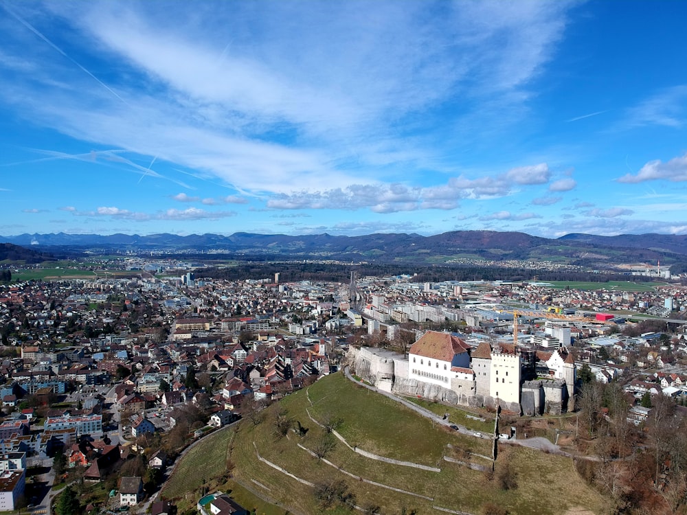 an aerial view of a city with mountains in the background