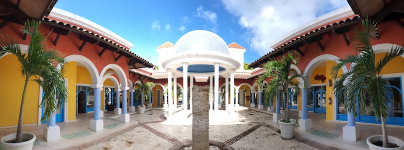 a courtyard with a fountain surrounded by palm trees