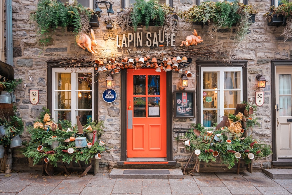 a red door is in front of a stone building