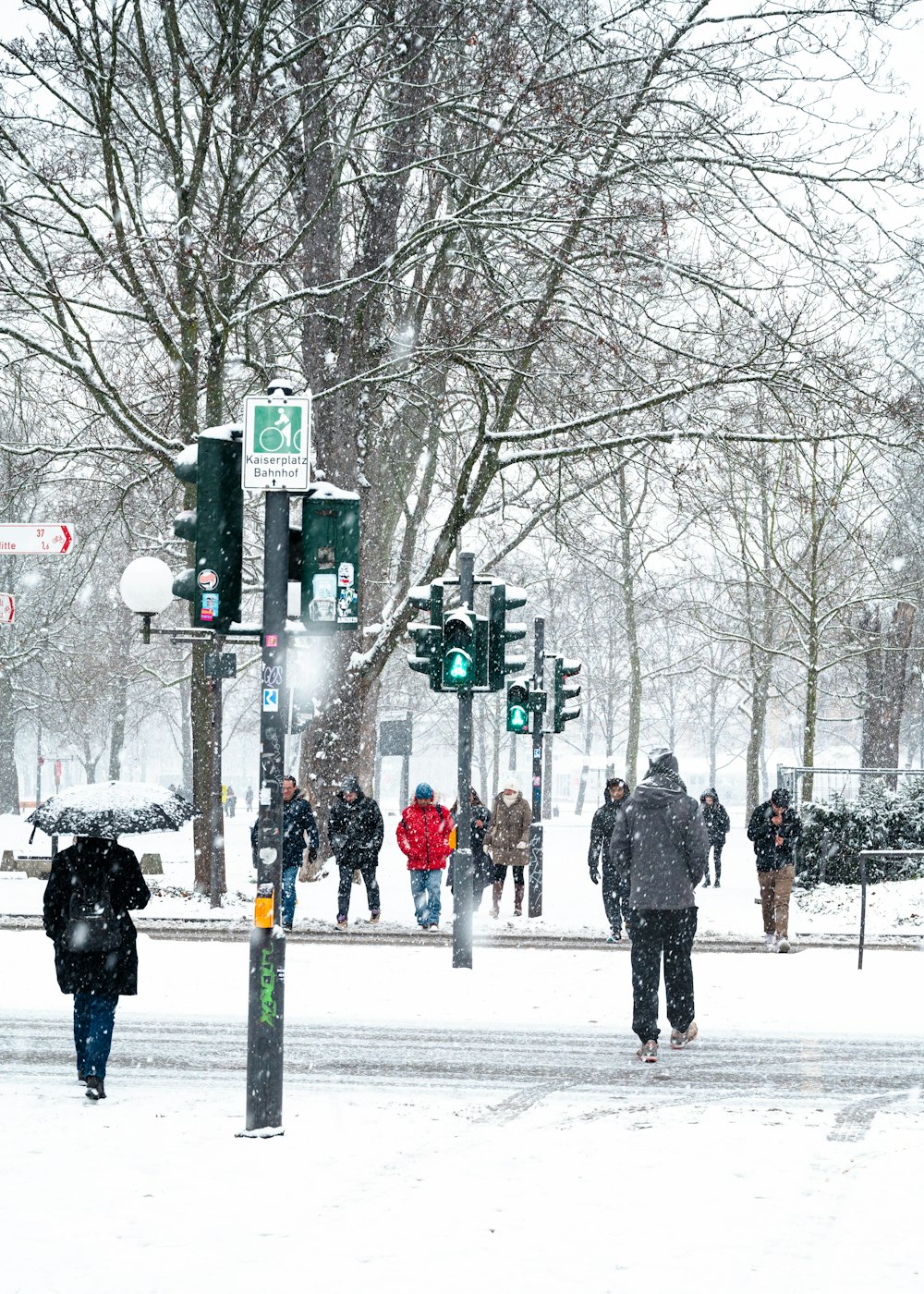 a group of people walking across a snow covered street