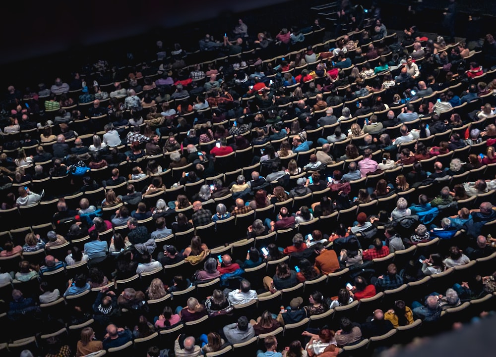 Un gran grupo de personas sentadas en un teatro