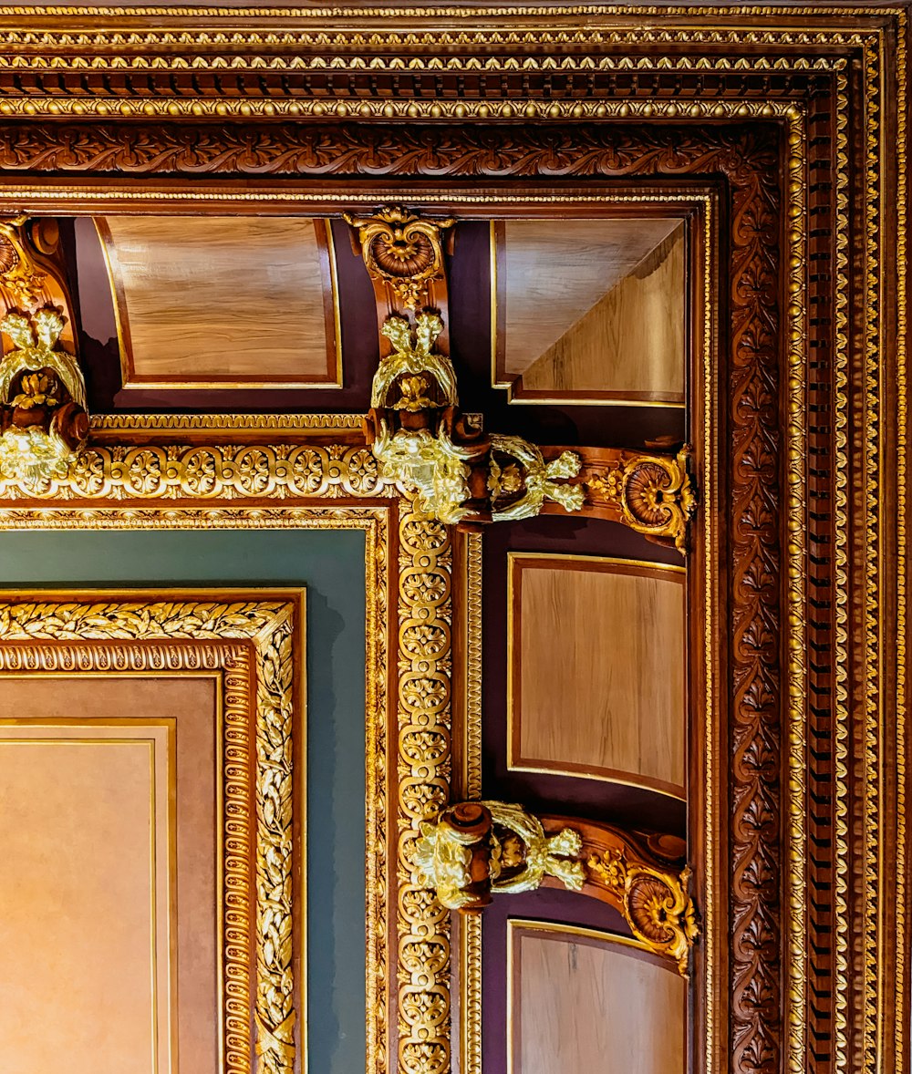 a close up of an ornate gold frame on a wall