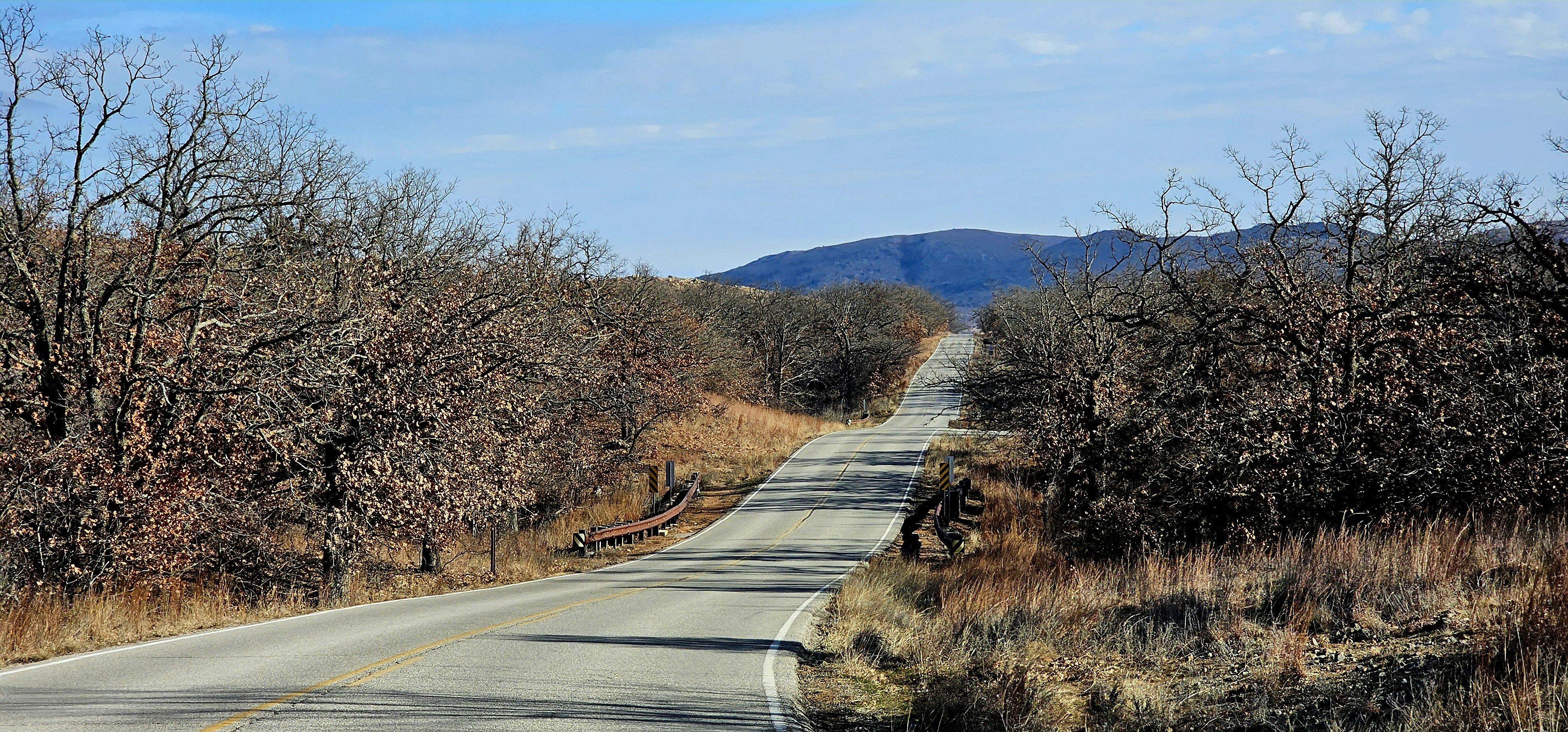an empty road in the middle of a wooded area