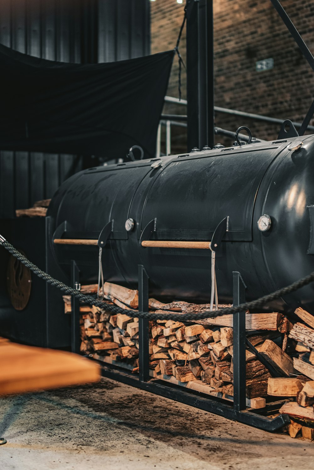 a large black tank sitting on top of a pile of wood