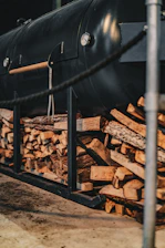 a train is parked next to a pile of logs