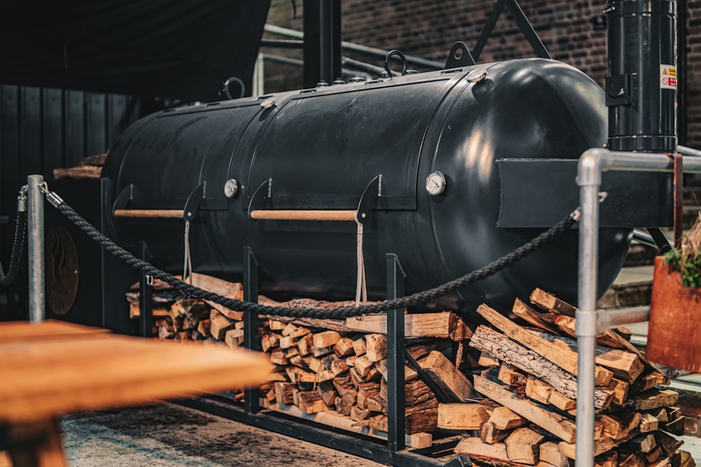 a large black tank sitting on top of a pile of wood