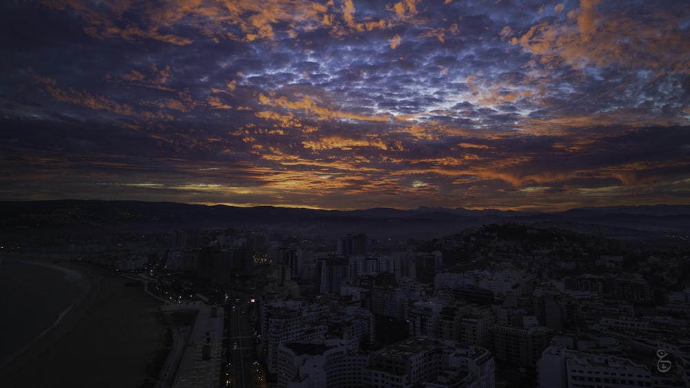 a view of a city at night with clouds in the sky