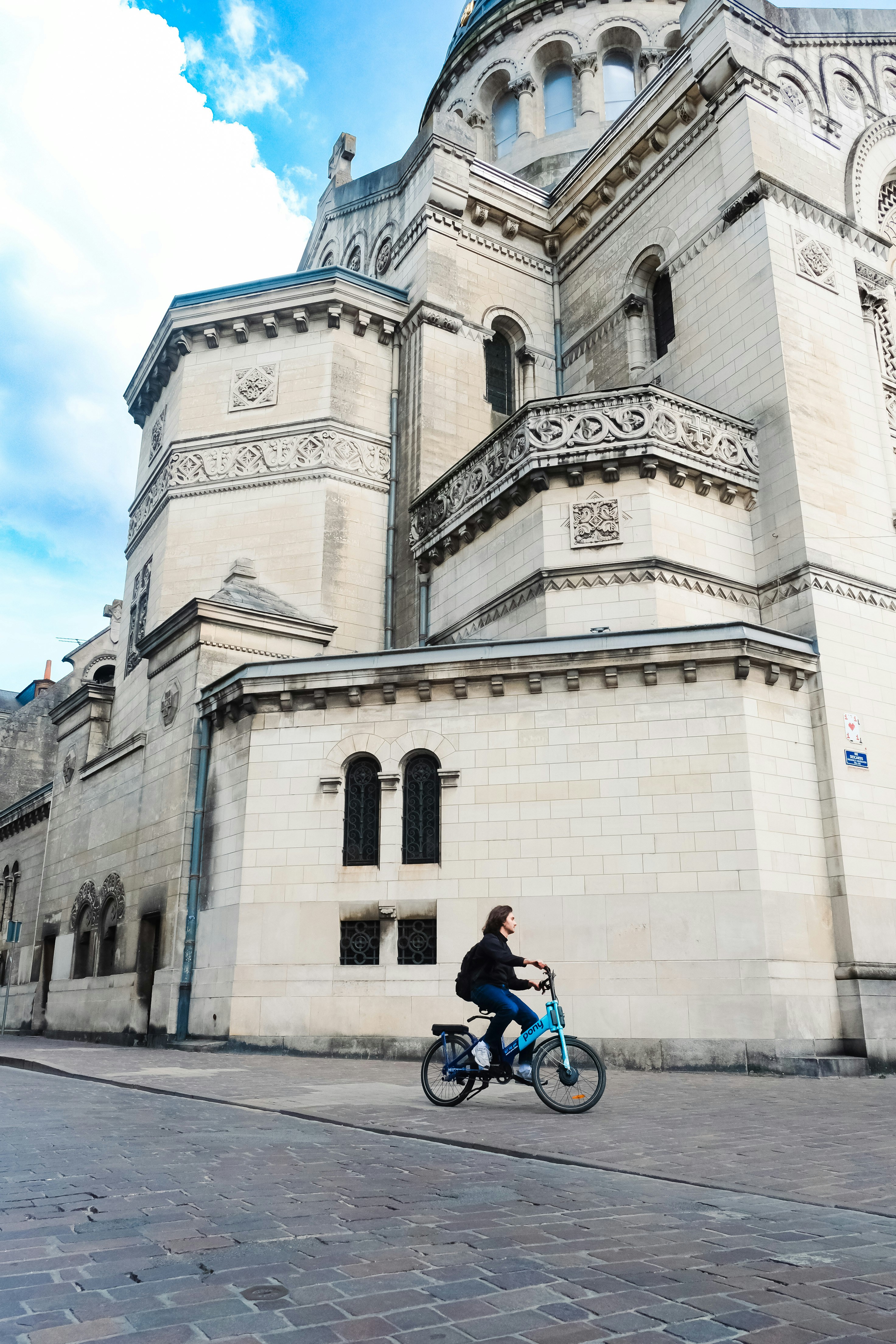 a person riding a bike in front of a building