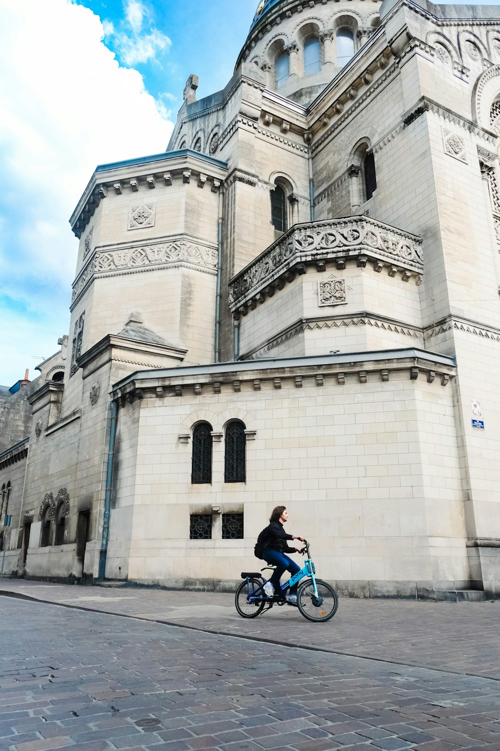 a person riding a bike in front of a building