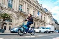a man riding a blue bike down a street