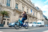 a man riding a blue bike down a street