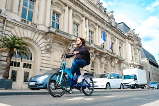 a man riding a blue bike down a street