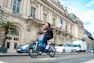 a man riding a blue bike down a street