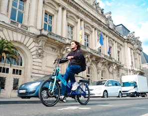 a man riding a blue bike down a street