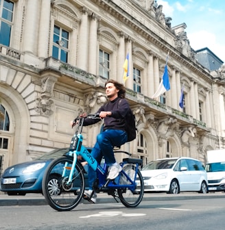 a man riding a blue bike down a street