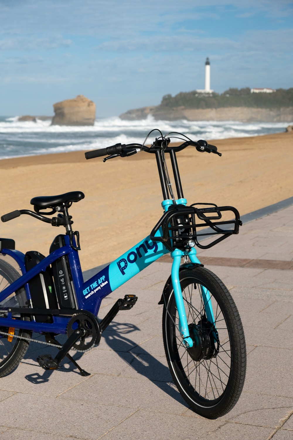 una bicicleta azul estacionada al costado de una playa