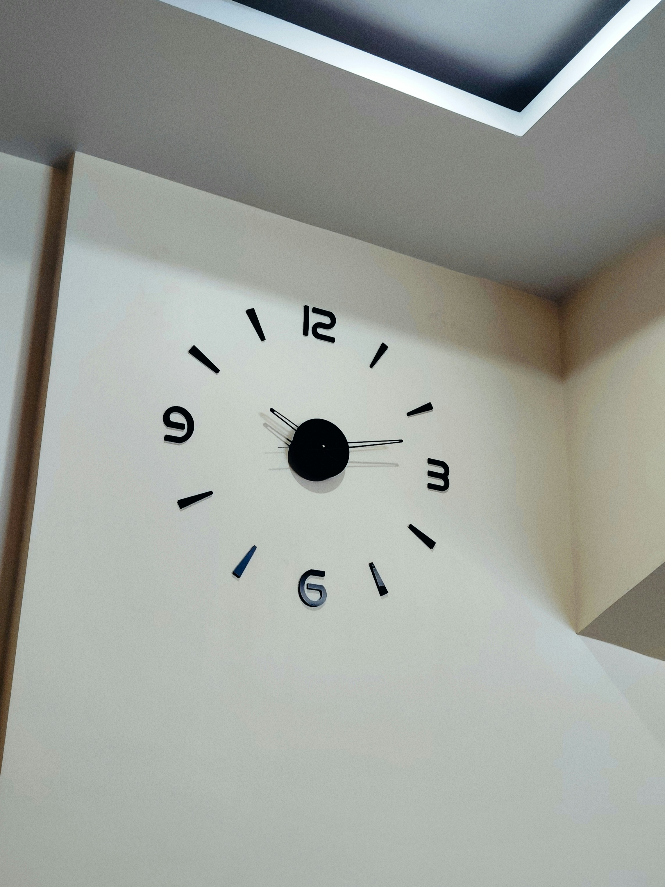 Minimalist modern wall clock on clean white wall in bright room