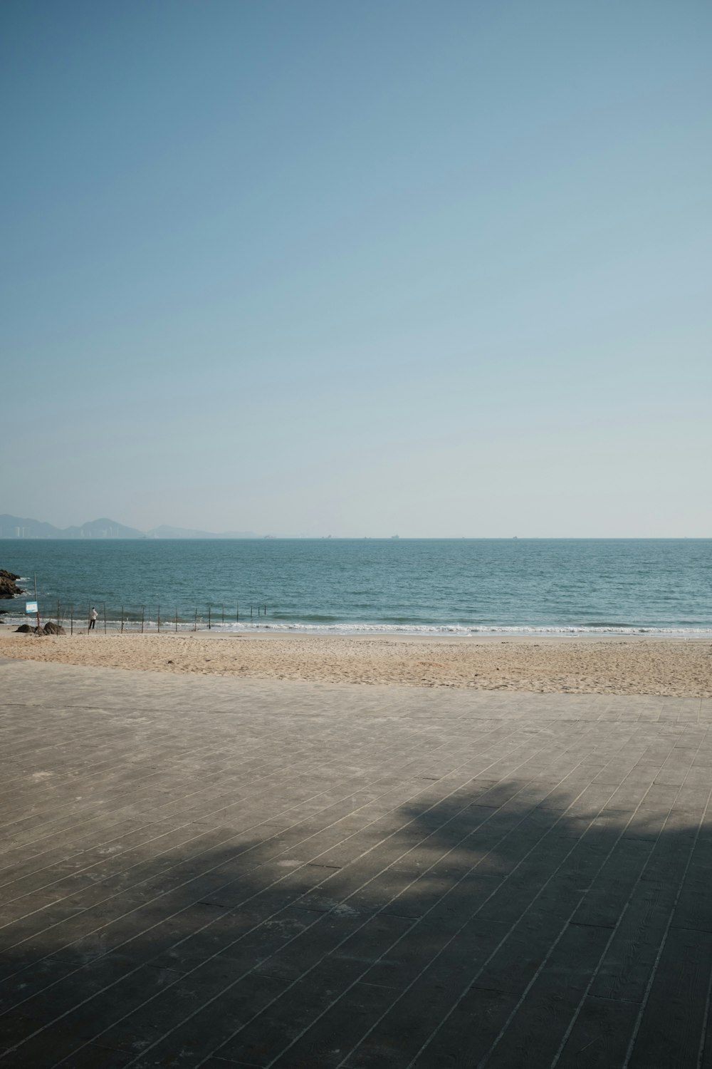 a person riding a skateboard down a sidewalk next to the ocean